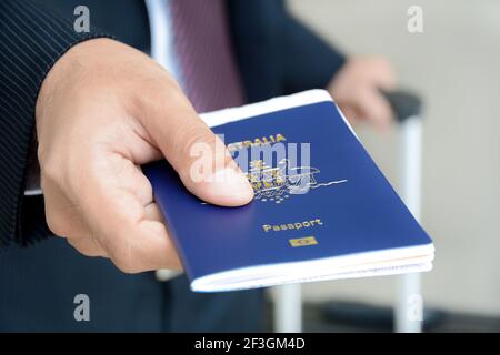 Uomo d'affari che mostra il passaporto (dell'Australia) Foto Stock