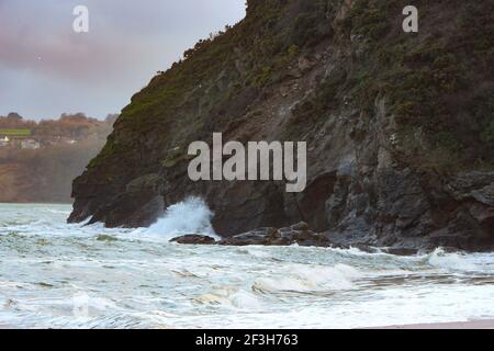 Tempesta atlantica ondate che si schiantano e lavano su rocce e. Sabbia sulla spiaggia di Carlyon Bay in Cornovaglia sul Costa sud-occidentale dell'Inghilterra Foto Stock