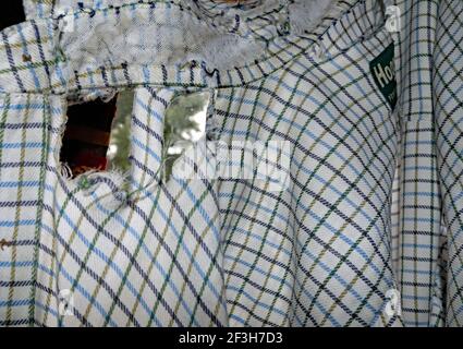 Una vecchia camicia molto amata è giunta alla fine della sua vita utile. Il colletto della camicia è indossato e ci sono dei fori nel materiale della parte posteriore della camicia. Foto Stock