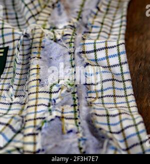 Una vecchia camicia molto amata è giunta alla fine della sua vita utile. Il materiale in cotone da cui è stata realizzata la camicia è stato indossato e reso nudo. Foto Stock