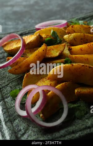 Piatto con spicchi di patate, prezzemolo e cipolla, primo piano Foto Stock