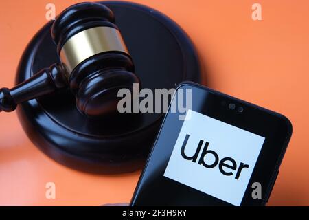 Il logo Uber visto sullo smartphone e giudica il gavel sullo sfondo sfocato. Concetto di sentenza della Corte, Uber diritti di conducente da parte della Corte Suprema. Stafford, Unite Foto Stock