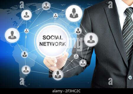 Mano di uomo d'affari che punta al SEGNO DI SOCIAL NETWORK sullo schermo virtuale con icone persone collegate come rete Foto Stock