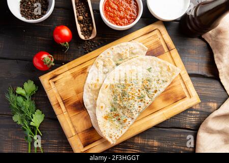 Gutab piatto nazionale azerbaigiano con carne e verdure insieme con yogurt e suma su tavola di legno Foto Stock