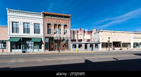 Vista sulla Main Street di Las Vegas, Santa Fe, con i suoi iconici negozi in stile occidentale e gli uomini che camminano oltre. Foto Stock