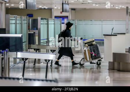 (210317) -- MANILA, 17 marzo 2021 (Xinhua) -- UN passeggero che indossa una maschera protettiva spinge un carrello bagagli dopo essere arrivato al terminal 1 dell'aeroporto internazionale Ninoy Aquino di Manila, Filippine, il 17 marzo 2021. Le Filippine hanno detto che sospenderà temporaneamente l'ingresso di stranieri e di alcuni cittadini, mentre il paese del Sud-est asiatico affronta un rinnovato picco nei casi COVID-19. In una dichiarazione rilasciata il martedì sera, la task force del coronavirus del paese ha dichiarato che i cittadini stranieri e i cittadini di ritorno che non avevano lavorato all'estero non potranno entrare nel paese da marzo Foto Stock