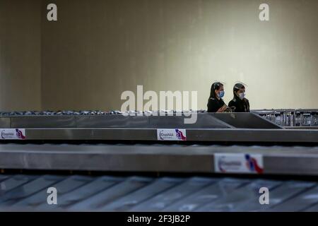 (210317) -- MANILA, 17 marzo 2021 (Xinhua) -- i dipendenti dell'aeroporto che indossano maschere facciali sono visti all'interno del terminal 1 dell'aeroporto internazionale Ninoy Aquino di Manila, Filippine, il 17 marzo 2021. Le Filippine hanno detto che sospenderà temporaneamente l'ingresso di stranieri e di alcuni cittadini, mentre il paese del Sud-est asiatico affronta un rinnovato picco nei casi COVID-19. In una dichiarazione rilasciata il martedì sera, la task force del coronavirus del paese ha detto che i cittadini stranieri e i cittadini di ritorno che non avevano lavorato all'estero non potranno entrare nel paese dal marzo 20 fino al 19 aprile sotto Foto Stock