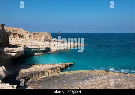 Costa maltese con vista sull'acqua di mare di Sant'Elmo e sul faro di Sant'Elmo, vista dal forte di Ricasoli Foto Stock