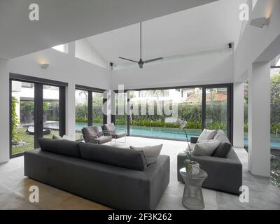 Soggiorno con vista della piscina in casa moderna, Swiss Club Road, Singapore Foto Stock