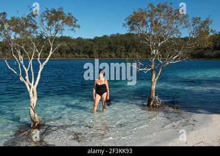 Una donna che bagna nel lago Mckenzie (Boorangoora) sull'isola di Fraser in Queensland, Australia Foto Stock