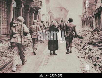 La foto archivistica di una donna anziana vede i danni mentre i soldati americani avanzano. Germania. 1945 Foto Stock