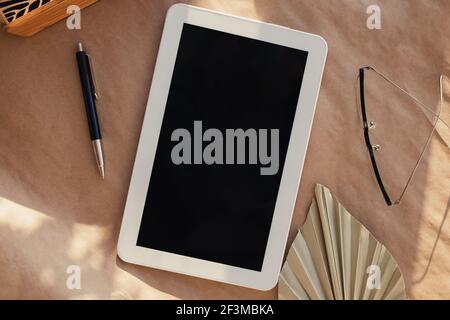 Tablet con schermo nero vuoto su carta artigianale Foto Stock
