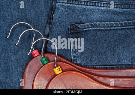 Appendiabiti con etichette in plastica multicolore su sfondo denim. Foto Stock