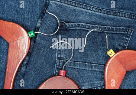 Appendiabiti con etichette in plastica multicolore su sfondo denim. Foto Stock