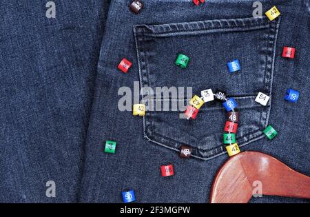 Appendiabiti con etichette in plastica multicolore su sfondo denim. Foto Stock