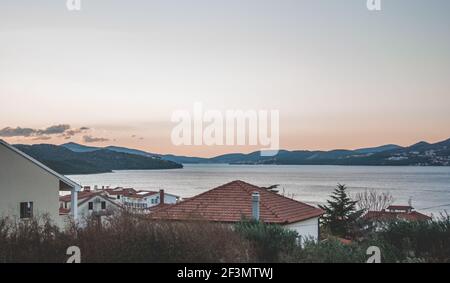 Splendida vista panoramica sul mare e sulle montagne in lontananza in Croazia. In primo piano case residenziali bianche con tetti rossi. Terre estive Foto Stock