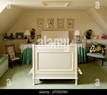 Camera da letto mansardata per bambini con letto singolo bianco e carta da parati a motivi Foto Stock