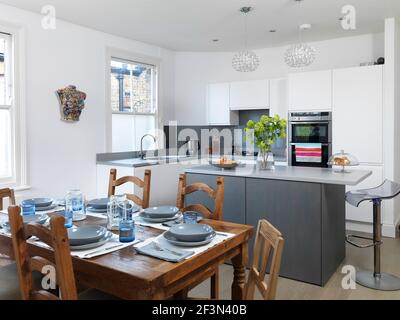 Tavolo in legno impostato nella cucina moderna, Regno Unito home Foto Stock
