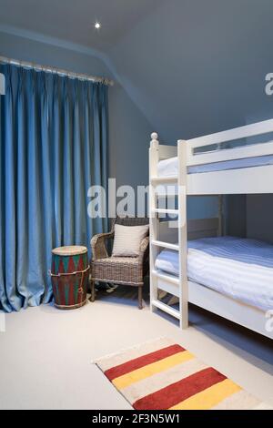 Grande casa di famiglia a Wandsworth, con seminterrato e cucina a pianta aperta estensione. Camera per bambini con letto a castello e tende blu Foto Stock