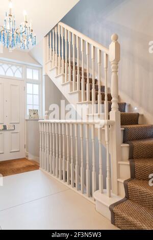 Grande casa di famiglia a Wandsworth, con seminterrato e cucina a pianta aperta estensione. Corridoio con scala dipinta di bianco con banisters Foto Stock