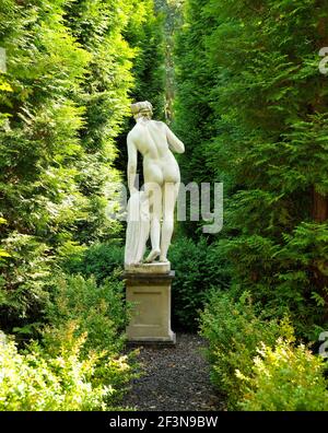 Vista posteriore di una scultura femminile in un giardino formale. Foto Stock