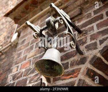Dettagli architettonici storici si possono vedere in tutta Bruges, qui una vecchia campana adorna la porta dell'ospedale di San Giovanni del XII secolo. Foto Stock