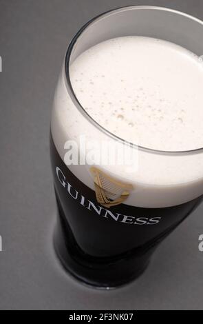 bicchiere di birra alla spina guinness su sfondo grigio Foto Stock