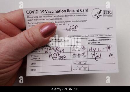 Paziente in possesso della scheda di registrazione vaccinata Covid 19 Foto Stock