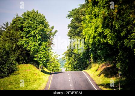 Campagna rurale strada collinare autostrada con colline ondulate in Virginia con alberi estivi tetto verde, cielo blu Foto Stock
