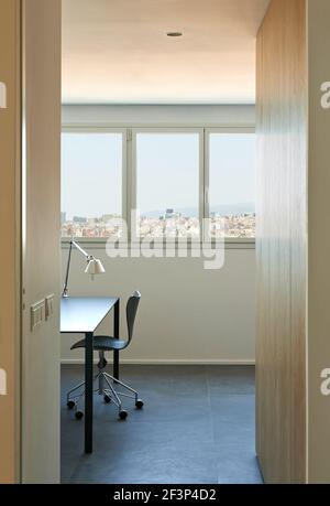 Appartamento El Escorial, Barcelona, Spagna. Vista parziale di un moderno tavolo e sedie attraverso una porta. Foto Stock