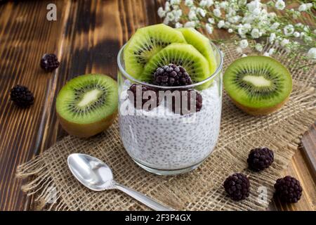 Pudding con chia, kiwi e mora su rustico sfondo di legno Foto Stock