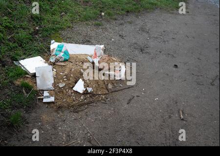 I rifiuti dei costruttori sono scappati sul lato di una strada rurale del norfolk. Foto Stock