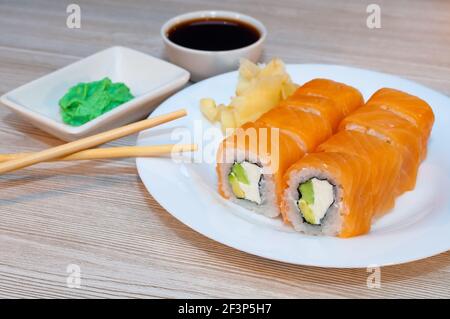 Panini con avocado di pesce e cetriolo in un piatto con salsa di soia e wasabi Foto Stock
