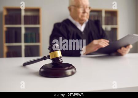 Primo piano di un gavel di legno posto sul blocco sonoro sul tavolo del giudice in aula durante l'udienza di corte. Foto Stock