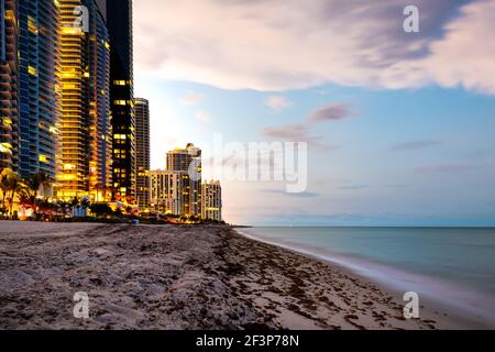 Lunga esposizione di appartamenti hotel o edifici condominiali al tramonto sera crepuscolo a Sunny Isles Beach di Miami, Florida con cielo colorato Foto Stock