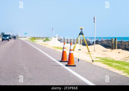 Costruzione attrezzatura topografica theodolite livello utensile su strada asfalto pavimentazione lavori con auto in background in amache, Florida by Atlantic oc Foto Stock