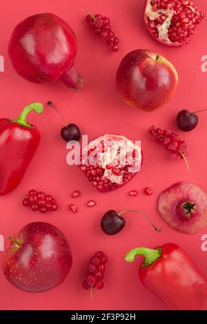 Vista dall'alto di verdure rosse e frutta sullo sfondo rosso. Posizione verticale. Foto Stock