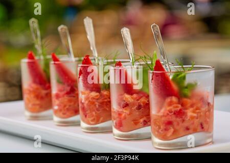 Spuntino al salmone o tartaro con fragole in vetro. Shalow dof Foto Stock