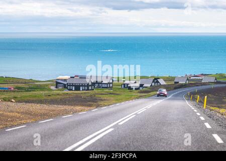 Hellnar, Islanda vicino al parco nazionale nella penisola di Snaefellsnes con molte case e vista panoramica delle acque blu chiaro dell'oceano Atlantico Foto Stock