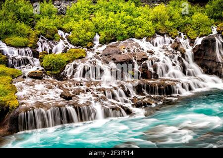 Acqua colorata blu acquatica turchese vivace colore acqua sulla cascata Cascades Hraunfossar Lava Cascate in Islanda closeup vista paesaggio Foto Stock