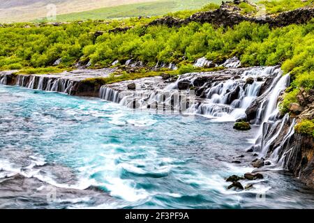 Colorato azzurro acquatico turchese color acqua sulla cascata Cascades Hraunfossar Lava Cascate in Islanda closeup vista paesaggio Foto Stock