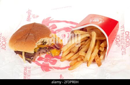 Open Wendy's Bacon Double Stack Cheeseburger con Bite Taked & French Fries aka chips su Wrapper Foto Stock