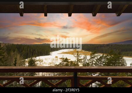 Vista dalla torre di guardia in un parco, bianco splendido tramonto e lago ghiacciato. Foto Stock