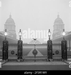 OLD ROYAL NAVAL COLLEGE, Greenwich, Londra. Vista misty dei cancelli in ferro battuto e dei gatelier al Royal Naval College su Romsey Road, che mostra il Foto Stock
