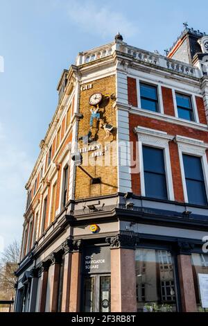 Il Guinness Clock all'angolo della Archway Tavern, male in bisogno di riparazione, Navigator Square, Londra, Regno Unito Foto Stock