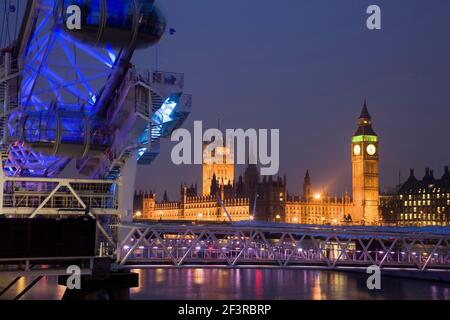 Vista sul Tamigi di notte, che mostra la ruota del London Eye in primo piano e le Camere del Parlamento illuminate, Londra, Regno Unito. Foto Stock