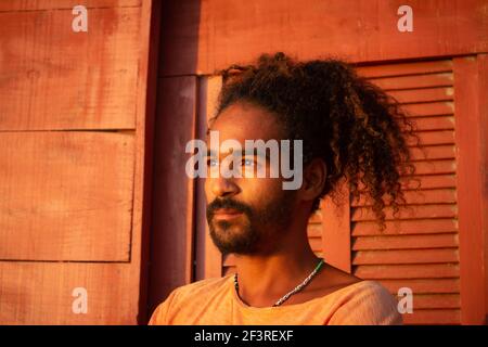 Triste uomo nero. Lunghi capelli ricci su un giovane di etnia brasiliana. Concetto di tristezza pandemica e ansia. Uomo bearded Foto Stock