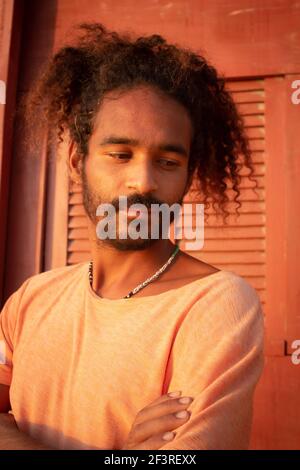 Triste uomo nero. Lunghi capelli ricci su un giovane di etnia brasiliana. Concetto di tristezza pandemica e ansia. Uomo bearded Foto Stock