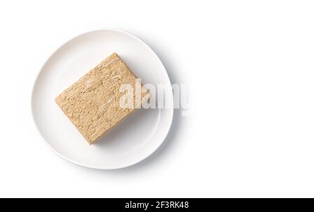Dolci orientali, halva su un piatto bianco. Vista dall'alto, oggetto isolato. Foto Stock
