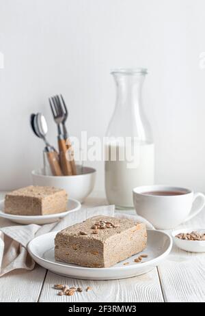 Ancora vita con halva su uno sfondo chiaro. Vista verticale. Il concetto di dolci orientali. Foto Stock